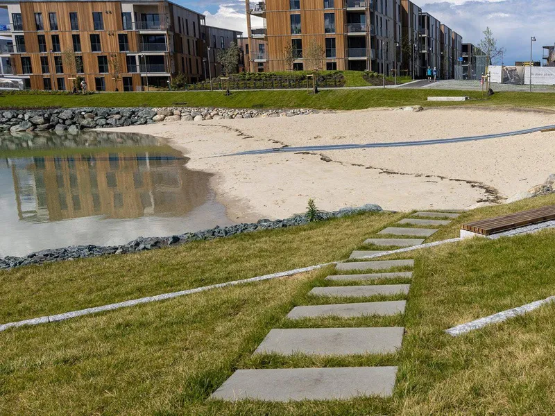 Tråkkheller ned til stranda og en smal blå gummimatte oppå sanden legger til rette for at alle trygt kan komme seg ned til vannet. Foto: Asplan Viak