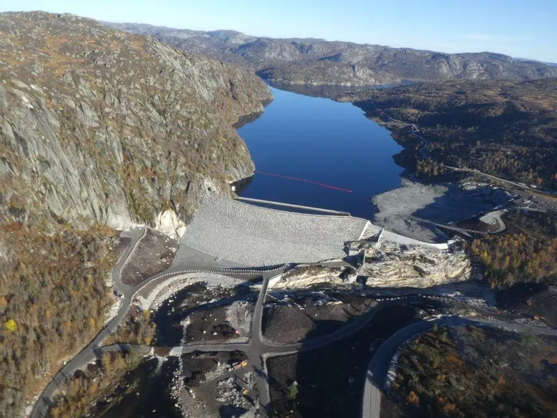 Dam, vannmagasin, fjell, himmel. Foto.