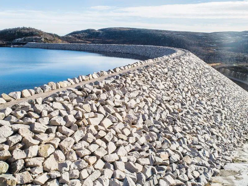 Dam, vannmagasin, fjell, himmel. Foto.