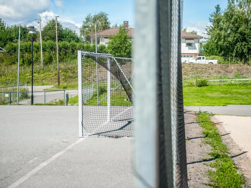 En inngjerdet håndballbane med et mål.