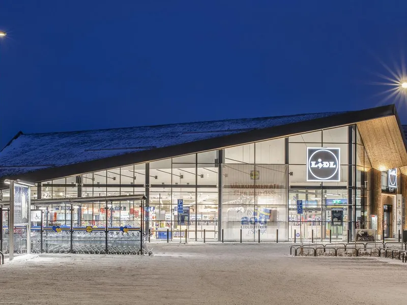 Fasade med store glassflater og skråttak. Foto