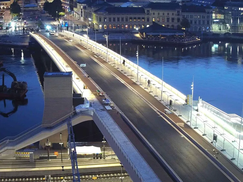 Bilde av en helt ny bybru tidlig en morgen. Fortauet er lyst opp. 