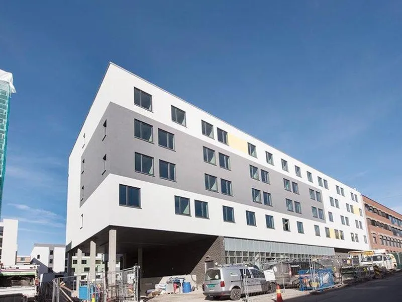 Foto av lyst bygg i seks etasjer, vinduer mm