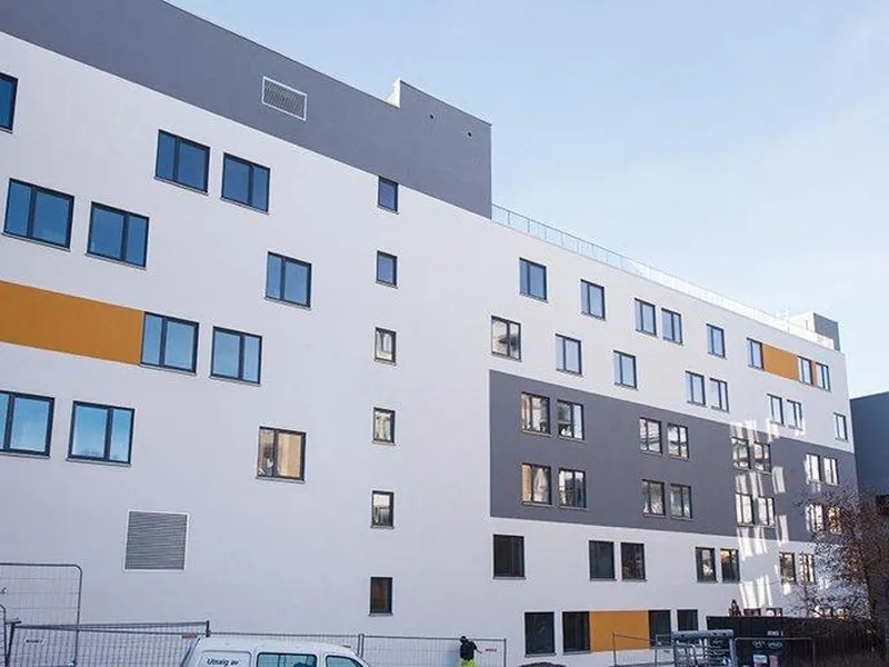 Foto av lyst bygg i seks etasjer, vinduer mm