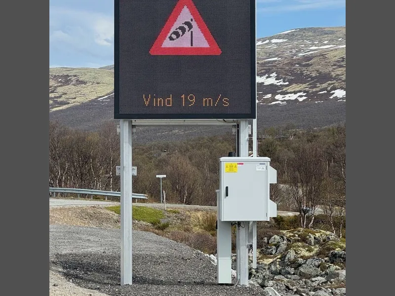 Digital skilttavle som viser vindpølse-symbol og tekst: Vind 19 m/s.