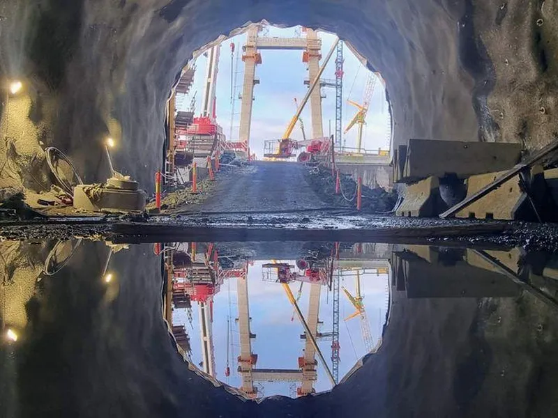 Utsikt frå tunnelportalen i Drotningsvik der riksvegen kjem ut.  Drotningsviktunnelen kjem ut frå fjellet og rett ut på Nye Sotrabru. Tunnelen er hovudsakleg drive frå Storavatnet og vestover med unntak av 50 meter som er drive frå Drotningsviksida. Gårsdagens gjennomslag ligg kring 50 meter inn i tunnelen frå portalen i bilete.