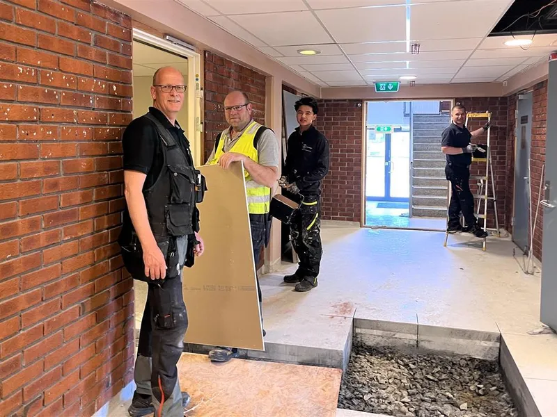 Arbeidere jobber på i en stor gang - Klikk for stort bilde