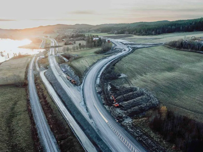 Dronebilde fra strekningen. Rasområdet er til venstre bak i bildet, og den midlertidige veien går på oversiden av bebyggelsen.