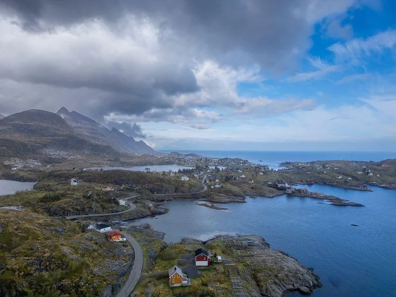 Dronebilde av E10 i Moskenes kommune. bildeteksten sier, E10 på strekningen Nappstraumen-Å, er tidvis smal og svingete uten midtstripe. Som her ved Tind mot Sørvågen i Moskenes kommune.