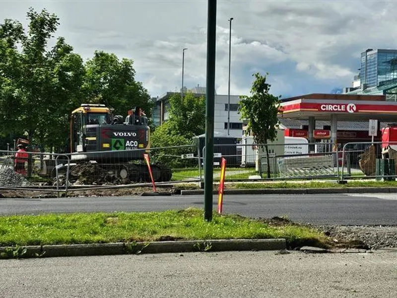 asfaltert veg med gravemaskin bak - Klikk for stort bilete