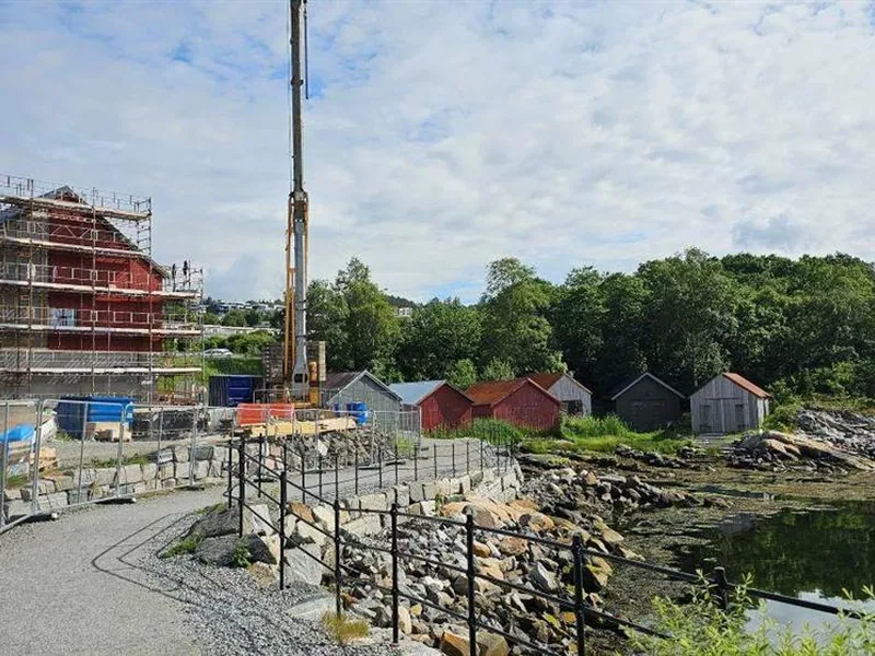 stort, raudt, uferdig hus med stillas rundt - Klikk for stort bilete