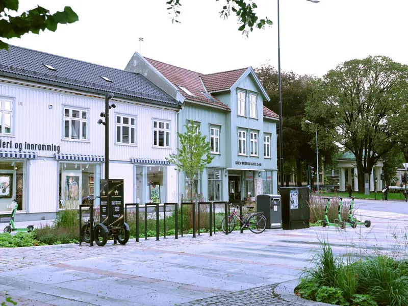 Oversiktsbilde over Farmannstorvet i Tønsberg sentrum med tilrettelegging for myke trafikanter med universell utforming, grønne oppholdsarealer og sykkelstativ.