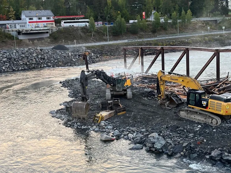 Riving av bro med gravemaksin ved vannet