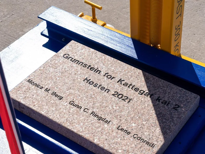 Bilde av graa, firkantet grunnstein med teksten : Grunnstein for Kattegat kai 2 Hoesten 2021 og ordfoerernes navn