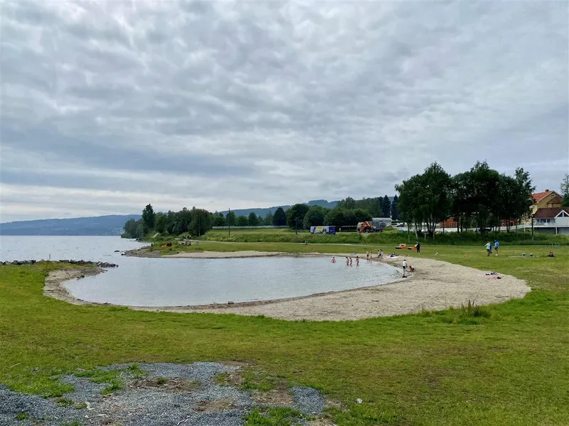 Fra badstua kan du se rett ned på badekulpen i Fredevika. Der er det sand slik at det er godt å gå ut i badevannet.  - Klikk for stort bilde