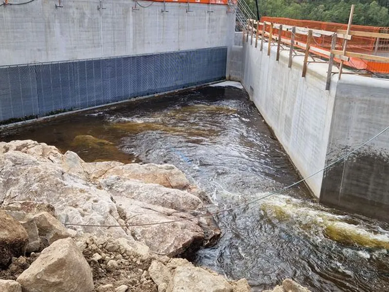 Anleggsområde, dam, inntaksrist, vann, skog. Foto.