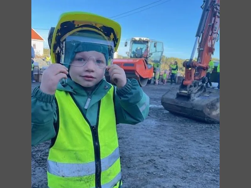 Eirik Landås (3) prøver en arbeidshjelm - Klikk for stort bilde
