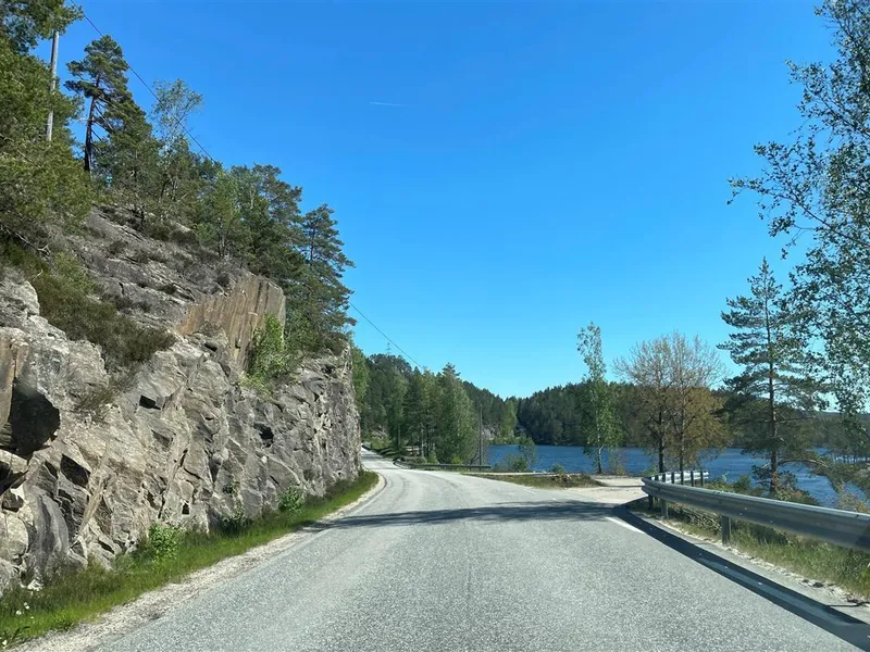 Foto av parti av fylkesveg 403 sør for Skaiå, tett på fjell uten grøft - Klikk for stort bilde