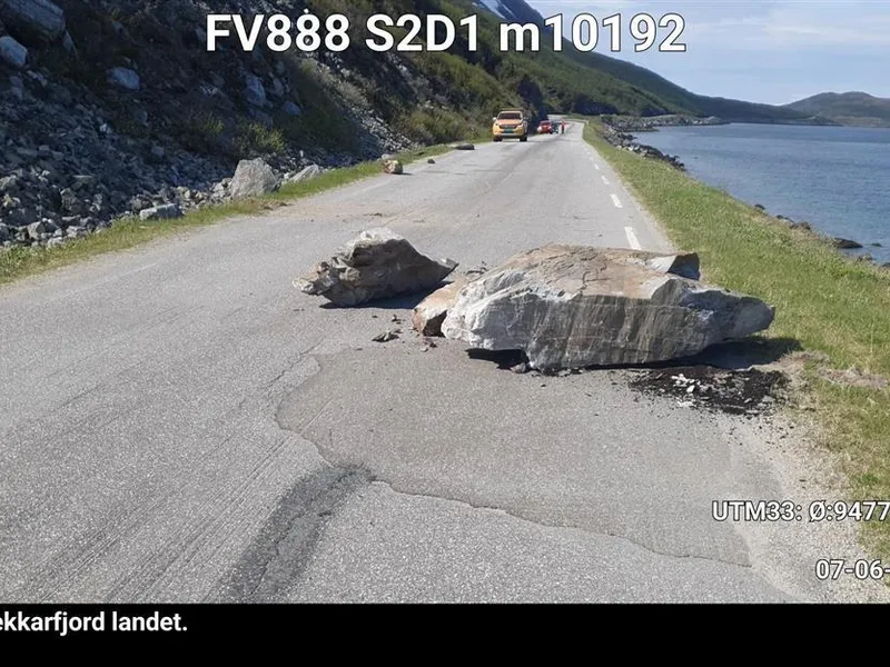 En fylkeskommunal vei, flere større steiner i veibanen, det har gått et ras. Bildet er tatt på sommerhalvåret. - Klikk for stort bilde