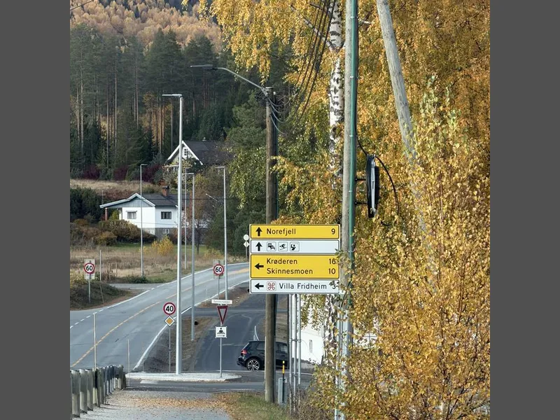 Gang- og sykkelvei, skilt, lyktestolper, blå himmel - Klikk for stort bilde