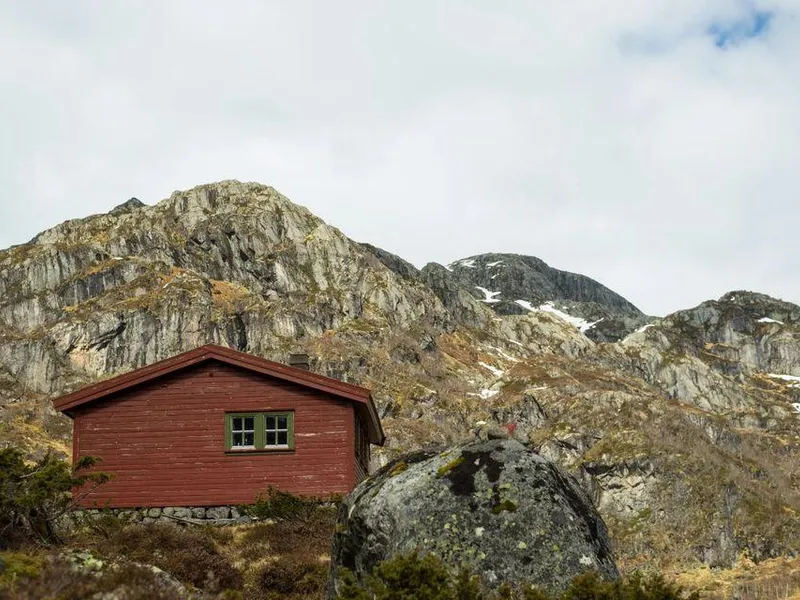 Rød DNT-hytte i steinete fjellandskap i Ryfylke.