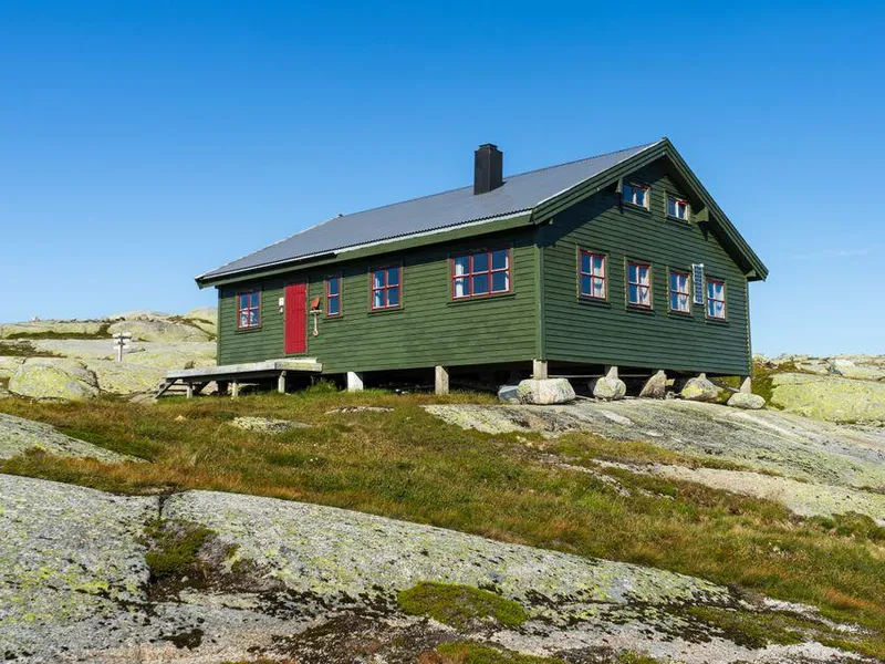 Grønn DNT-hytte i steinete fjellandskap ved Eidavatn i Ryfylke.