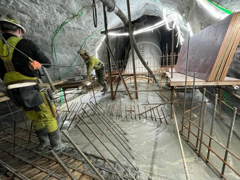 Byggeplass, arbeidsfolk, betongstøping. Foto.