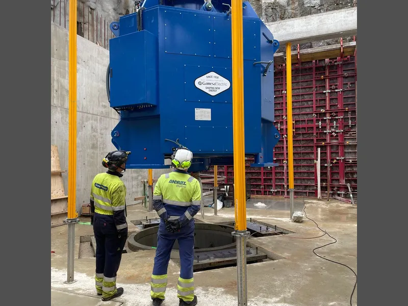 Byggeplass, to menn i arbeid, generator. Foto.