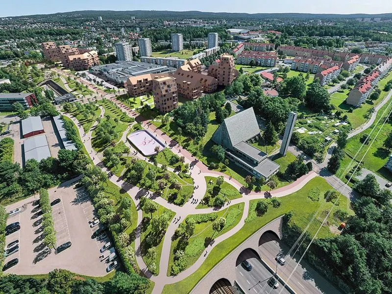 Slik kan et miljølokk over E6 på Manglerud bli. Illustrasjonen viser også eksempler på hvordan tomter langs motorveien kan brukes til boligbygging. Illustrasjon: Link Arkitektur
