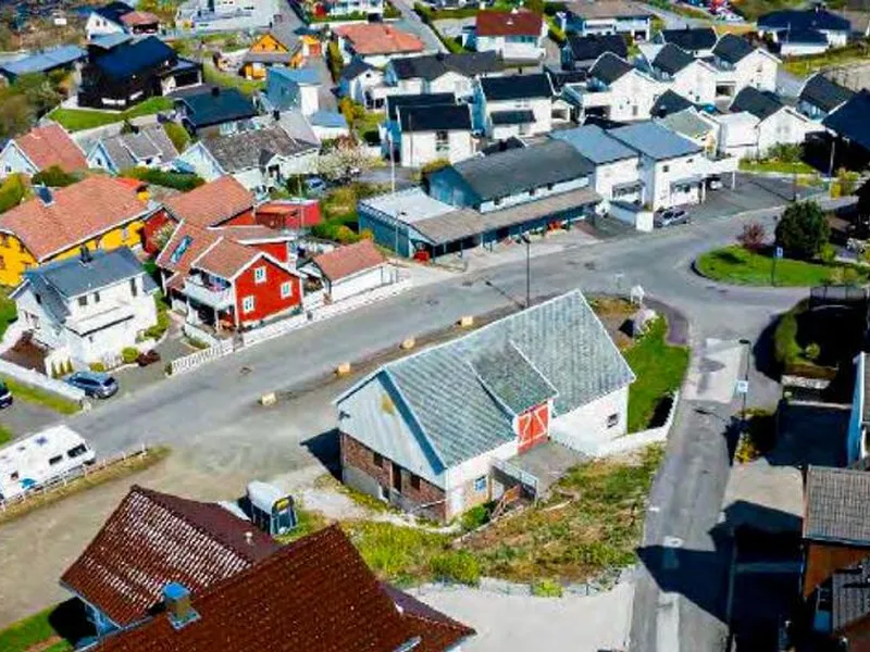 Dronebilde over planområdet i Hafsøy med låven i Hafsøy i sentrum
