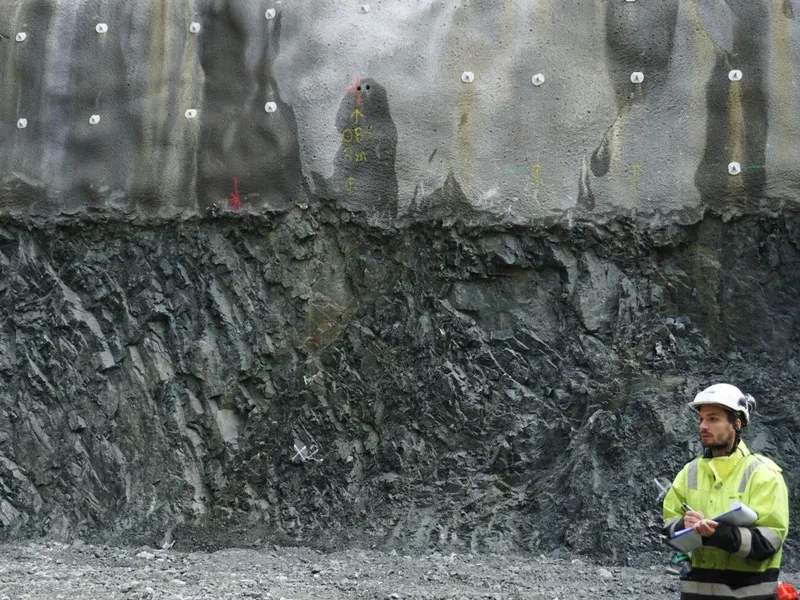 En mann i gule arbeidsklær og hjelm på byggeplass