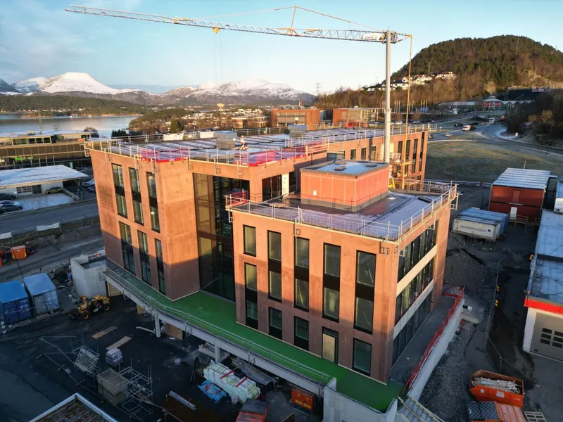 Dronebilde som viser byggeplassen på Holsletta, der Veidekke reiser et av landets første Svanemerkede kontorbygg i lavkarbon ekstrem betong. Foto: Veidekke.