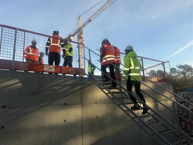 Folk går i en trapp på en byggeplass - Klikk for stort bilde