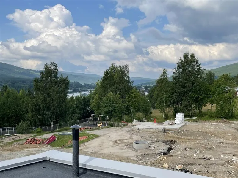 Utsikt mot ei elv, åssider og hus - Klikk for stort bilde