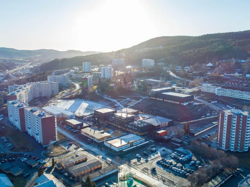 Dronebilder over Fjell, med ny skole, hall og blokkene rundt.
