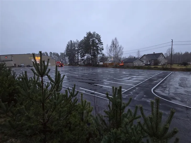 Bilde som viser den nyasfalterte parkeringsplassen mellom Otrahallen og Hornnes barneskule. Her har det blitt oppgradert iht trafikksikkerhetshensyn. Det har kommet ny drop-off-sone, parkeringsplass, gangveg for myke trafikanter og leveringssone for buss. - Klikk for stort bilde