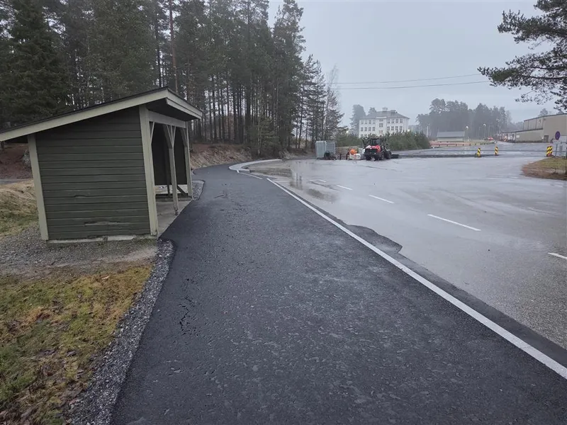 Bilde som viser den nyasfalterte parkeringsplassen mellom Otrahallen og Hornnes barneskule. Her har det blitt oppgradert iht trafikksikkerhetshensyn. Det har kommet ny drop-off-sone, parkeringsplass, gangveg for myke trafikanter og leveringssone for buss. - Klikk for stort bilde