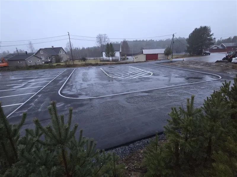Bilde som viser den nyasfalterte parkeringsplassen mellom Otrahallen og Hornnes barneskule. Her har det blitt oppgradert iht trafikksikkerhetshensyn. Det har kommet ny drop-off-sone, parkeringsplass, gangveg for myke trafikanter og leveringssone for buss. - Klikk for stort bilde