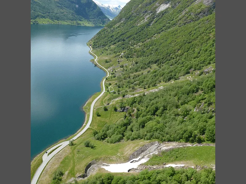 Eksisterande veg langs Kjøsnesfjorden med fleire rasløp nedetter fjellsida.