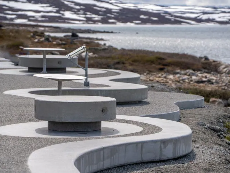 Bilete viser betongmøbler som buktar seg i ei mjuk linje ut mot det naturlege landskapet og skaper varierte og unike små tilhaldsstader.