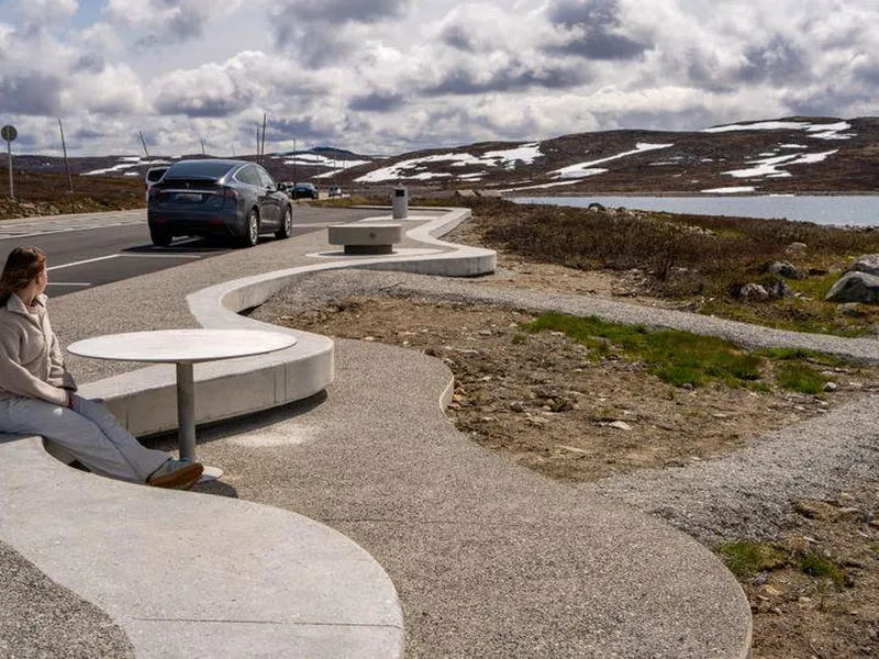 Ei ungjente sit på rasteplassen Ørteren og ser på utsikta over Hardangervidda.