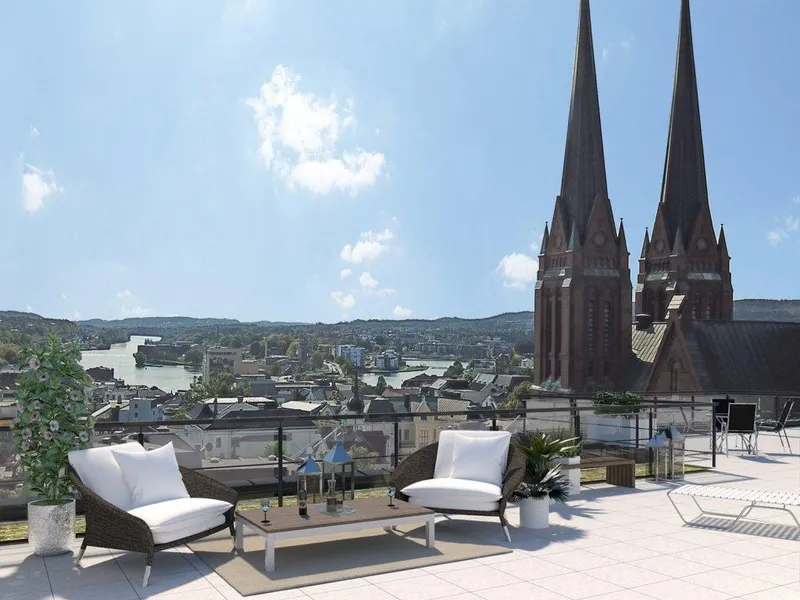 Illustrasjon av terrasse med to kirketårn, bysentrum og elv i bakgrunnen