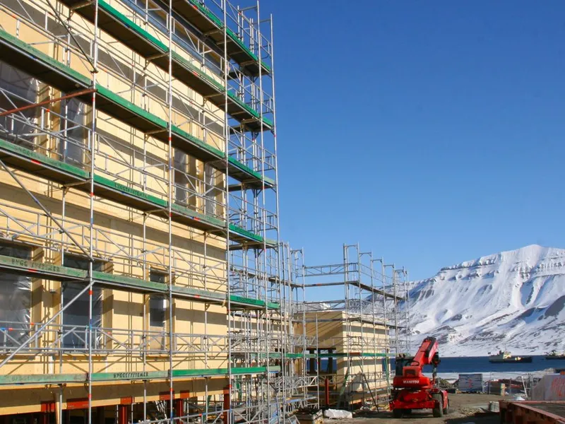 Den nye folkehøgskolen, som blir ført opp på Sjøskrenten i Longyearbyen, bygges i massivtre med solcelleanlegg på taket.Foto: Ramirent
