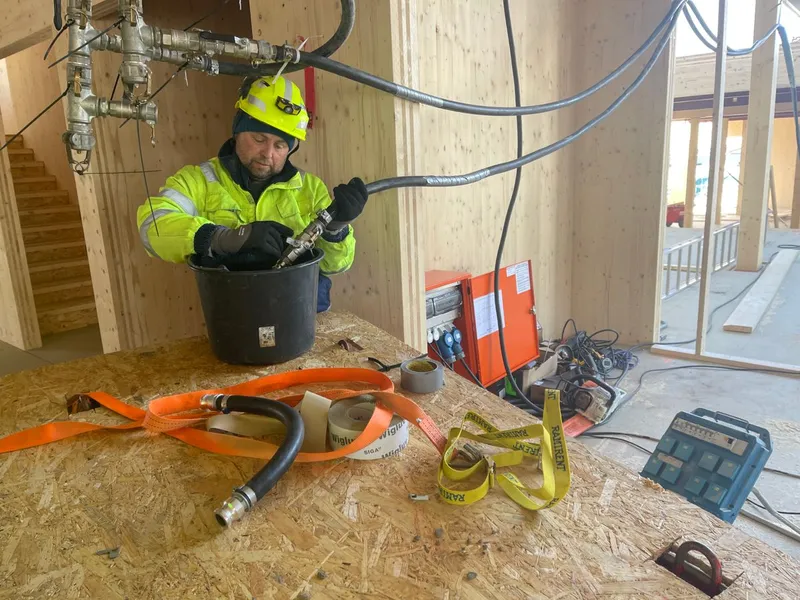 Ramirents montør Bjørn Villy Buskli i full sving med byggtørk-anlegget som er basert på fjernvarme.Foto: Ramirent