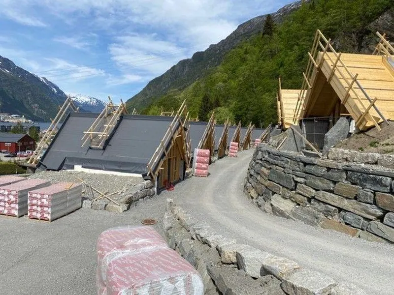 Campinghyttene ligger delvis nedgravd i terrenget. Torvtak, isolert med ROCKWOOL Rocktorv, bidrar til å gi et flott grønt uttrykk.