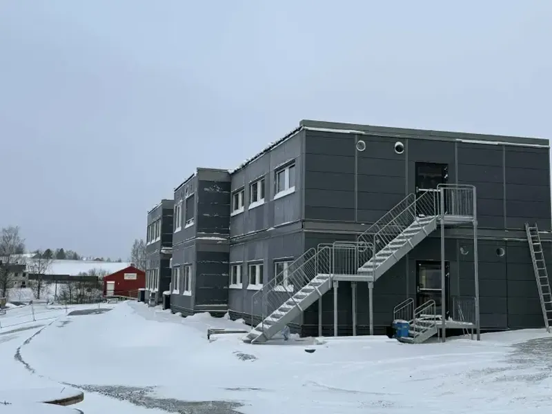 Et brakkebygg med snø på bakken