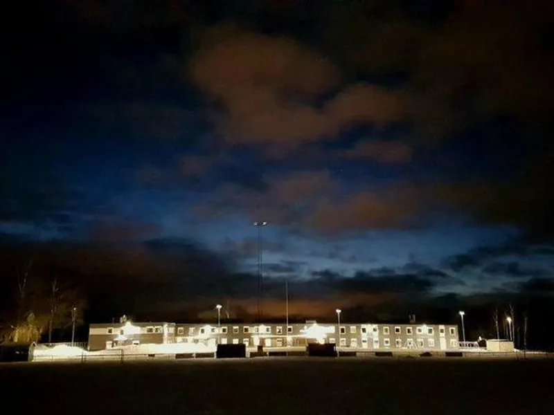 Modulskole i mørket med mørk blå kveldshimmel i bakgrunnen.