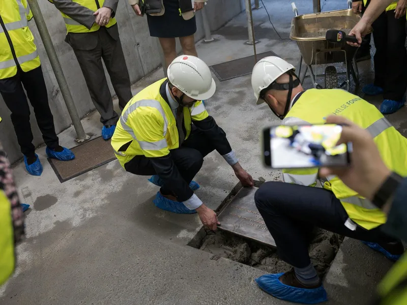 En gruppe mennesker i sikkerhetsvester som jobber på et rør