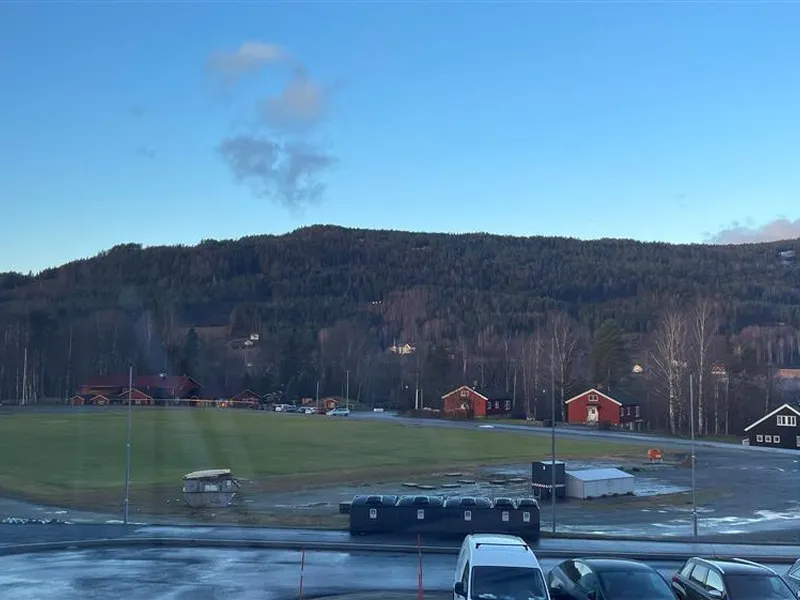 Oversiktsbilde av gressbane og friidrettsbane, blå himmel - Klikk for stort bilde