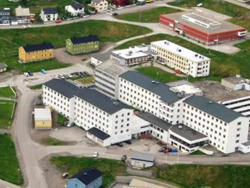 Flyfoto av Hammerfest sykehus omgitt av boliger og veier - Klikk for stort bilde